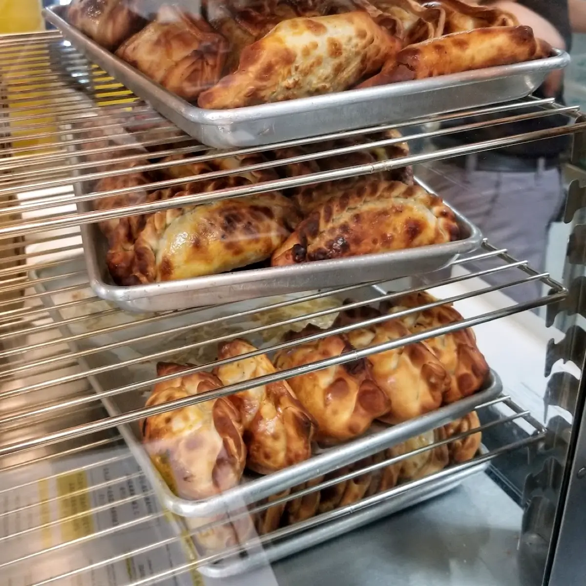 A variety of fresh baked empanadas in trays from Empanada Kitchen.