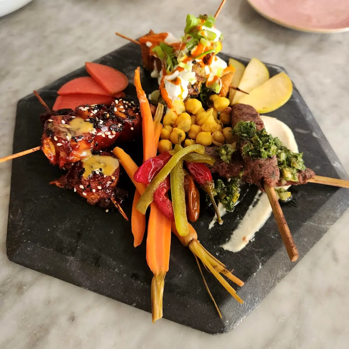 Several different kebabs and grilled vegetables from KINDRED. 