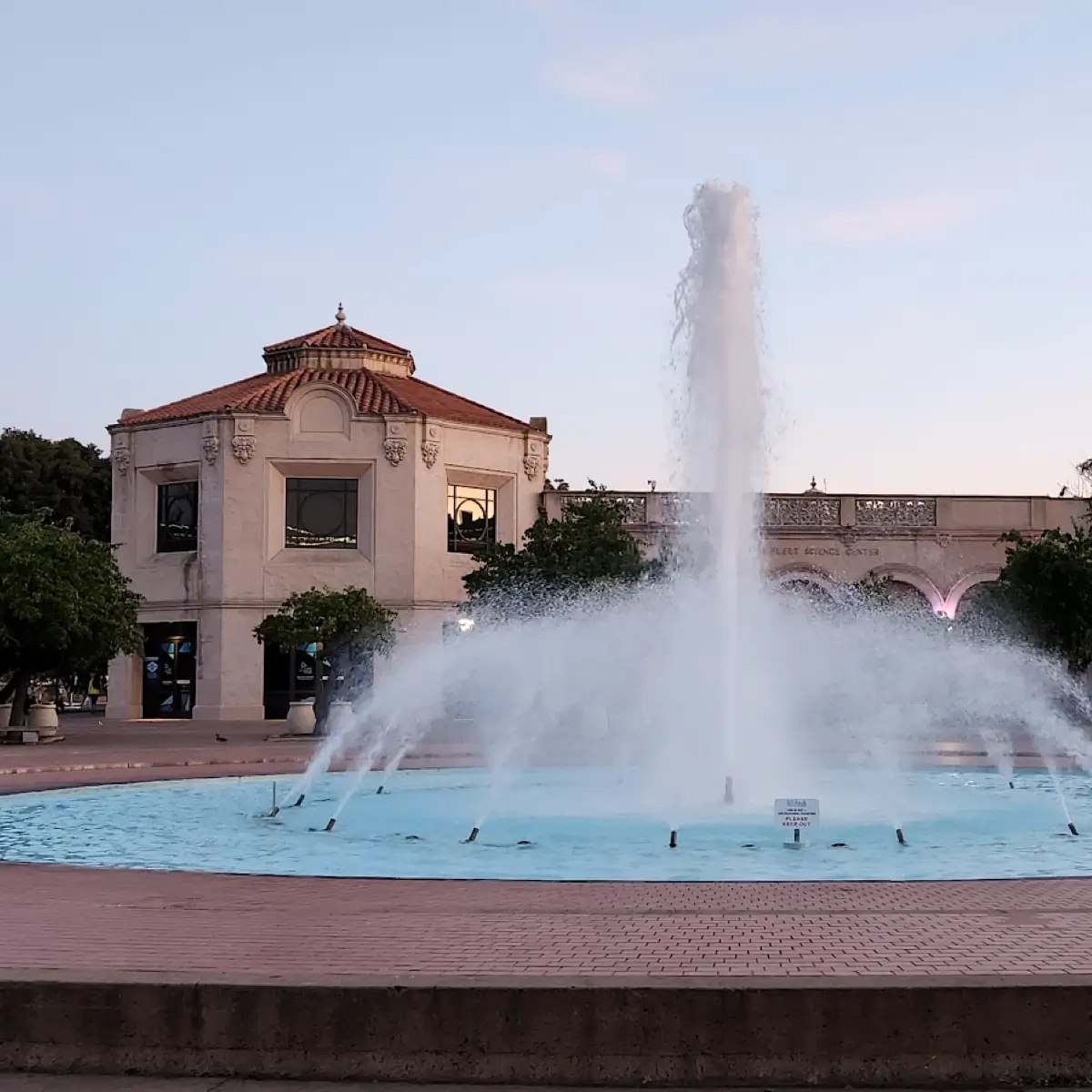 A view of the exterior of museum with water fountain in one of Balboa Park's plazas. 