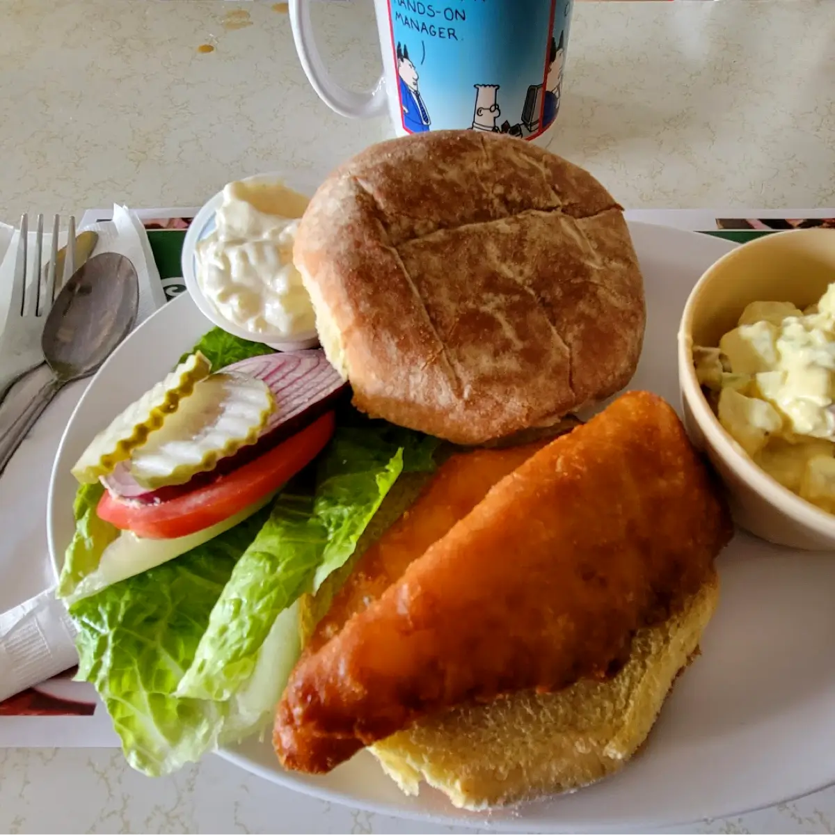 Burger with side and white bun at The Huddle. 