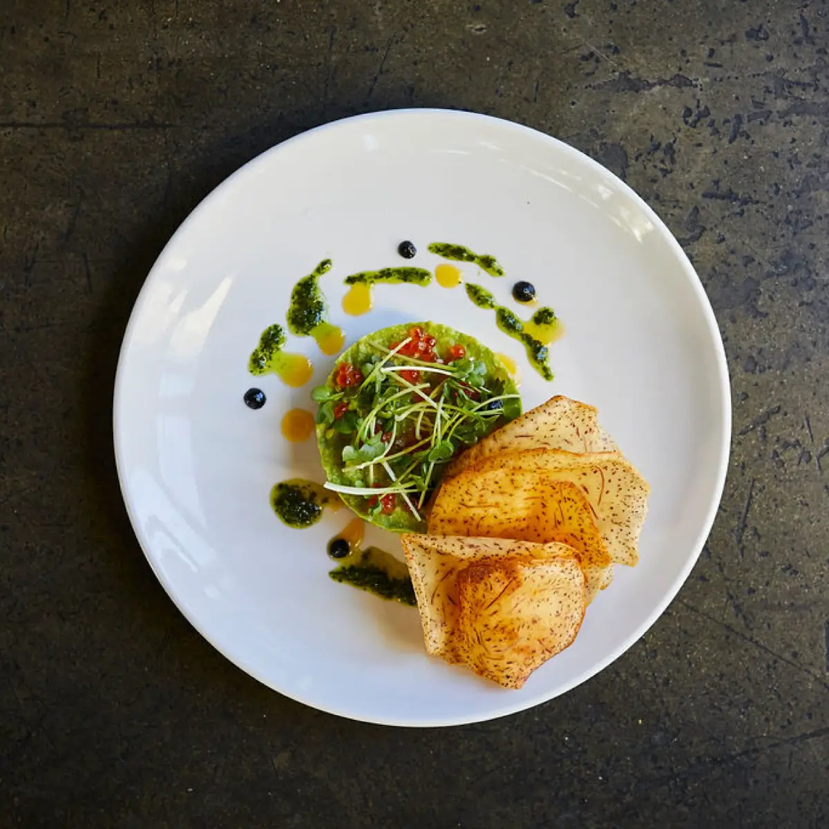 A beautifully plated seafood dish with chips at Trust Restaurant.
