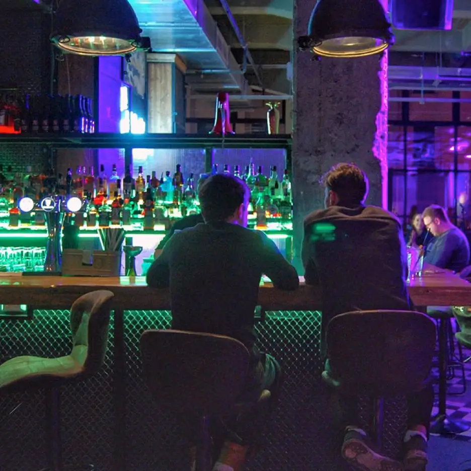 Two men sitting at an LGBTQ+ bar