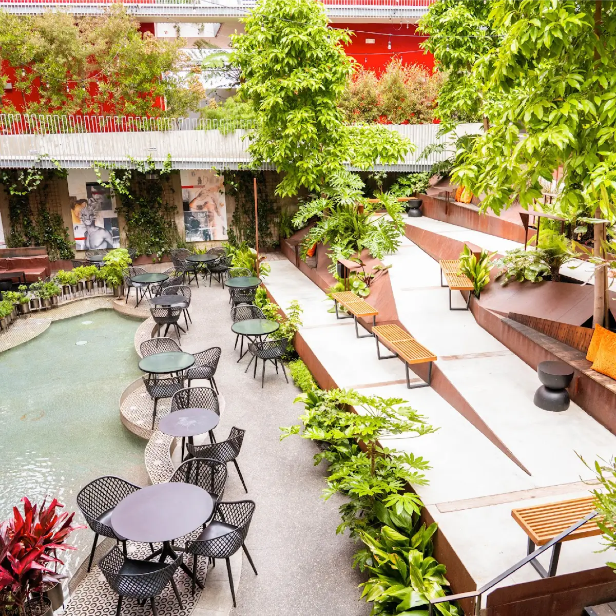 A view of the inside patio with water features, verdant plants, and tables at InsideOUT. 